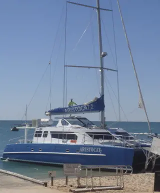 Fahre mit dem Rollstuhl auf einen Katamaran